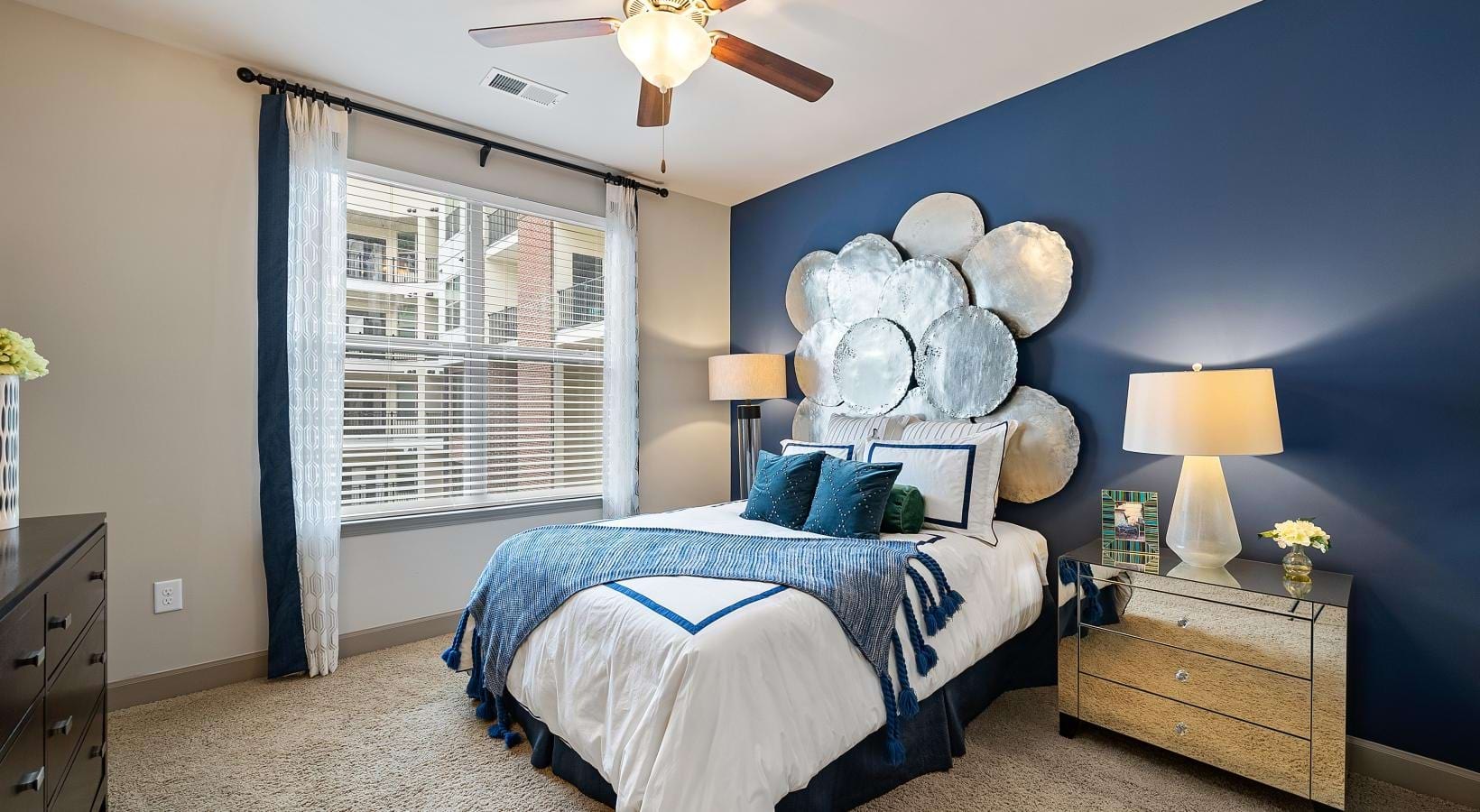 Relax and recharge in beautiful and spacious bedrooms a bedroom with a bed and a fan