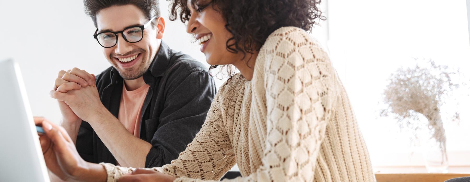 a man and a woman looking at a laptop